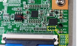 Zbliżenie na zieloną płytkę drukowaną z różnymi komponentami elektronicznymi.