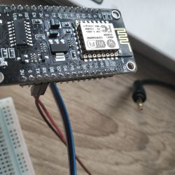 ESP32 electronic board on a wooden table with connected wires.