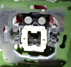 Rozkręcony wyłącznik elektryczny z trzema przewodami, z czego jeden ochronny jest niepodłączony.