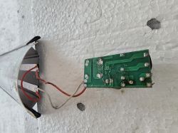Oderwane przewody w lampie LED z widoczną płytką PCB Zielona płytka PCB z oderwanymi przewodami w oprawie LED, widok z boku