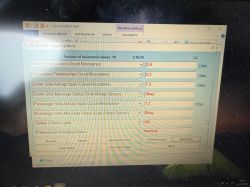 Ekran laptopa z programem OP-COM pokazującym pomiary obwodów napinaczy i poduszek powietrznych.