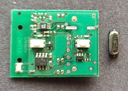 Close-up of a circuit board with electronic components and a separate component beside it.
