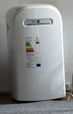 Biały klimatyzator przenośny BLYSS WAP-267EC ustawiony przy ścianie na podłodze.