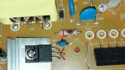 Damaged component on a circuit board with capacitors and a resistor.