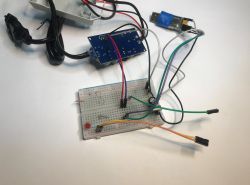 Programming ATLO-GDC2-TUYA Controller via USB-UART Breadboard with connected wires, ATLO-GDC2-TUYA garage door controller, and USB-UART converter on a white background.