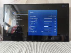 Telewizor Samsung wyświetlający menu z widocznymi pionowymi pasami i artefaktami na ekranie.