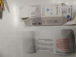Flattened temperature &amp; humidity sensor box from AliExpress with a folded instruction sheet on a white desk