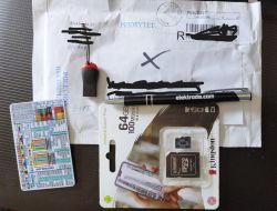 Envelope with electronic items including a USB drive, pen with elektroda.com logo, Kingston memory card, and resistor reference card.