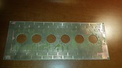 Printed Circuit Board with Holes Printed circuit board with six large round holes and intricate traces.