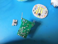 Electronic Components with Circuit Board and LED Module Electronic components on a blue background, including a green circuit board and an LED module.
