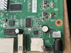 Zdjęcie płytki drukowanej z widocznymi elementami elektronicznymi, takimi jak kondensatory i układy scalone.