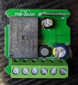 Close-up of a printed circuit board of an electronic device with visible components such as capacitors and screw terminals.
