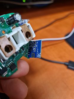 The image shows a circuit board with electronic components, held in a hand.