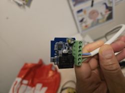 Mini smart switch with visible components held in hand.