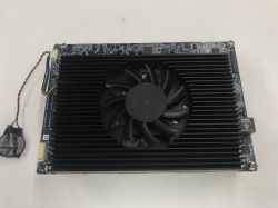 Karta elektroniki z dużym czarnym radiatorem i wentylatorem, obok przewód z baterią