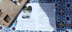 Sheet with technical instructions on a tiled surface with a metal element next to it.