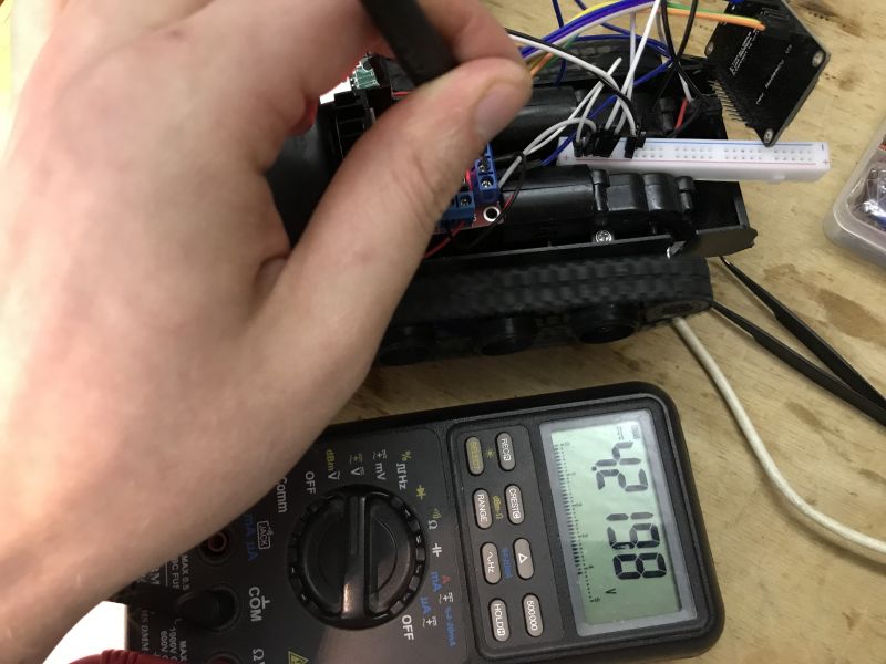 Voltage Measurement on Track Robot Hand measuring voltage with multimeter on track robot