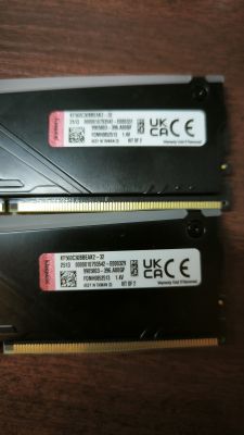 Dwie kości RAM Kingston KF560C30BBEAK2–32 na tle drewnianego blatu