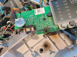 Zbliżenie na płytkę drukowaną i wyświetlacz elektroniczny w otwartym urządzeniu.