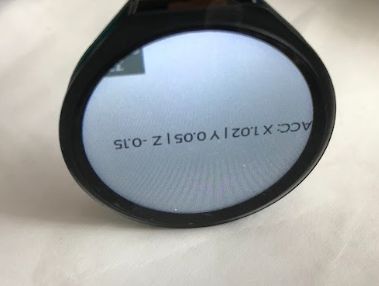 Okrągły ekran ESP32-S3-Touch-LCD-1.28 z wyświetlanymi danymi akcelerometru, obrócony do góry nogami.