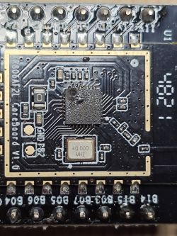 Close-up of an integrated circuit on a printed circuit board with a quartz resonator marked 40.000 MHZ.
