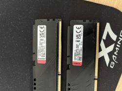 Dwie kości pamięci RAM Kingston DDR4 leżące na czarnej podkładce gamingowej