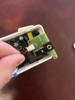 Image of the interior of an electronic device with a visible circuit board and a connected cable.