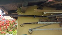 Makeshift pipe and plank system on the exterior wall of a building.