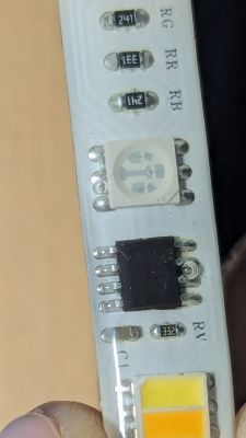 Close-up of an RGBIC LED strip showing electronic components.