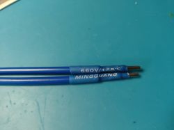 Two blue electrical wires with black ends and markings 660V/125°C MINGGUANG.