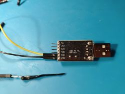 USB-TTL Converter with Wiring USB to TTL converter with attached cables on a blue background.