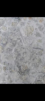 Fragment kamiennej ściany z szarymi i beżowymi elementami w zaprawie