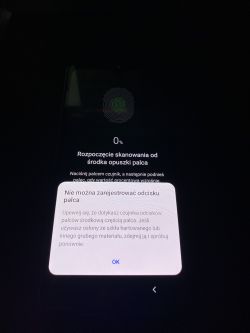 Ekran smartfona z opcją skanowania odcisku palca, z komunikatem o błędzie rejestracji.