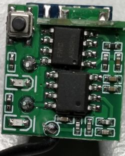 Electronic PCB with Integrated Circuits Close-up of an electronic PCB with components, including a button and integrated circuits.