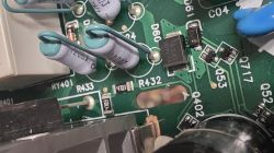 Zbliżenie na elementy elektroniczne: kondensatory, rezystory i układy scalone na płytce PCB.