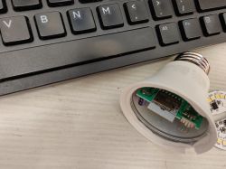Feit Electric A19 light bulb with exposed PCB module and a keyboard in the background.