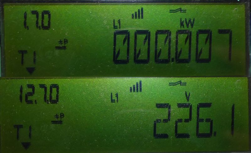Zbliżenie na ekran wyświetlacza licznika energii elektrycznej z odczytami mocy i napięcia.