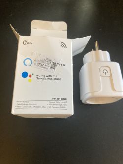 Smart Plug from Aliexpress and Packaging Smart plug and its packaging on a dark surface.
