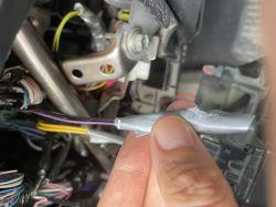 Zbliżenie na fioletowy kabel z czarnym oplotem połączony taśmą izolacyjną