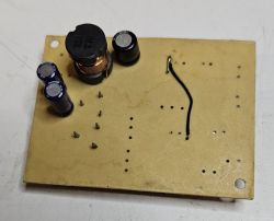 Płytka drukowana z kilkoma zamontowanymi komponentami elektronicznymi i ręcznie dodanym przewodem.