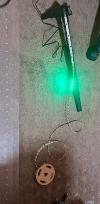 LED strip with glowing green LEDs placed on a carpet.