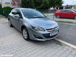 Silver Opel car parked on a sidewalk.