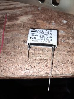 Kondensator TEAPO 0,22 µF 250V X2 leżący na drewnianym blacie