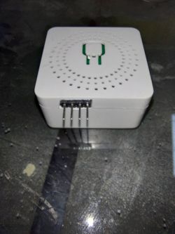 Photo of a white electronic device with pin connectors on the side.