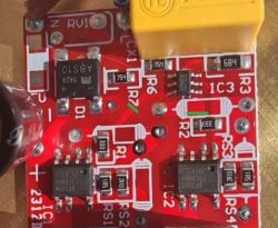 Czerwony PCB z opisami IC3 i IC2; zielony znak wskazuje miejsce przecięcia ścieżki