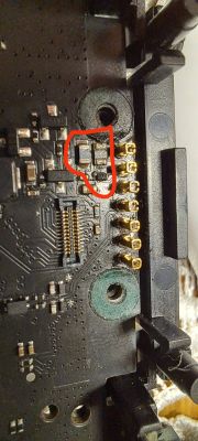 Zbliżenie na płytkę drukowaną z zaznaczonym na czerwono uszkodzonym elementem.