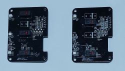 Two black PCBs with electronic components and labels.