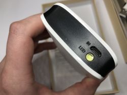 Zbliżenie na biały powerbank z portem microUSB i przyciskiem LED