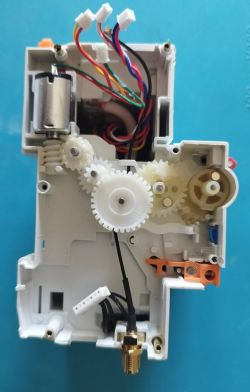 Interior view of a device showing a gear mechanism, an electric motor, and several connected wires.