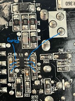 Zbliżenie na płytkę drukowaną z różnymi komponentami elektronicznymi i niebieskimi liniami wskazującymi.